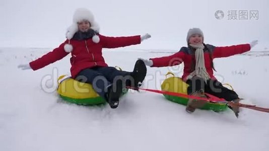 快乐的孩子们骑着雪山，在飞行中伸直手臂，笑着。 冬天在雪橇上快乐的童年视频