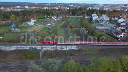 一辆红色的客运列车穿过奥格斯堡的绿色郊区视频