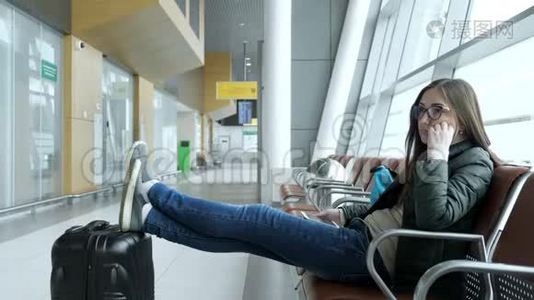 无聊的年轻女子正坐在大厅的机场等待她的航班。视频