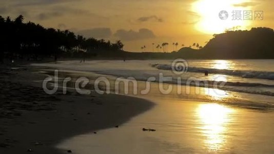 日落时，软波在局部海水海滩上冲刷. 夕阳西下，沙滩上海面上一片片平静。 太阳视频