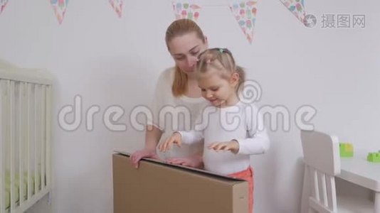妈妈和女儿为一个孩子打开一个新买的大纸盒视频