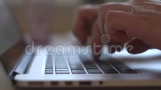 双手特写，用黑色按键和光屏在笔记本电脑键盘上工作和打字视频