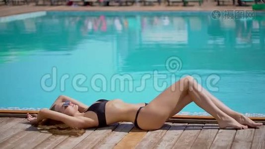 夏天美丽的年轻女子。 比基尼女孩在热带游泳池放松。 日光浴，日光浴的女人视频