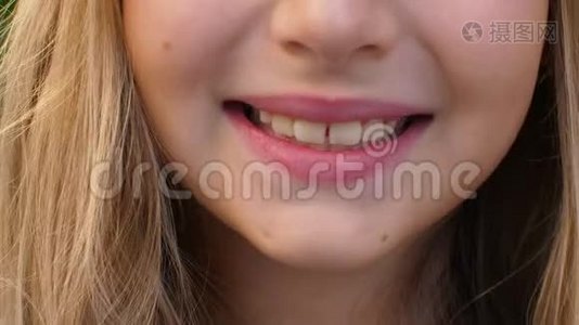用白色的牙齿和美丽的嘴唇微笑着的前置摄像头，将少女拉近视频