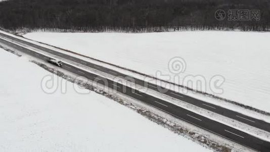 汽车在路上行驶，冬天的时候。 空中观景。视频