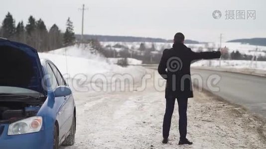 男子乘坐硬纸板在冬季乡村道路搭便车视频