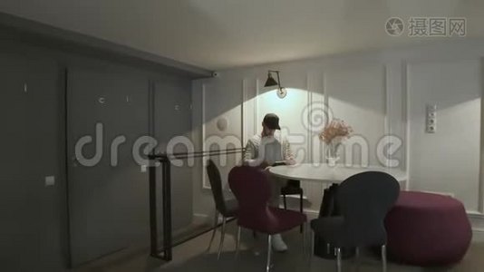 戴帽子的人坐在桌上，端着平板电脑视频