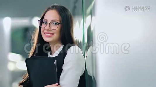 一位戴着眼镜、站在走廊上的迷人成功微笑女商人视频