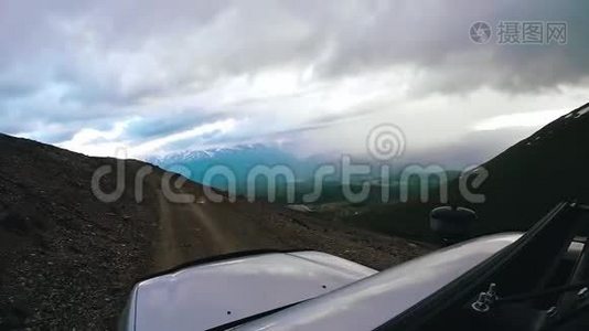 阴天开车上坡.. 汽车旅行：POV-观点SUV骑着一个山谷与山脉在一起视频