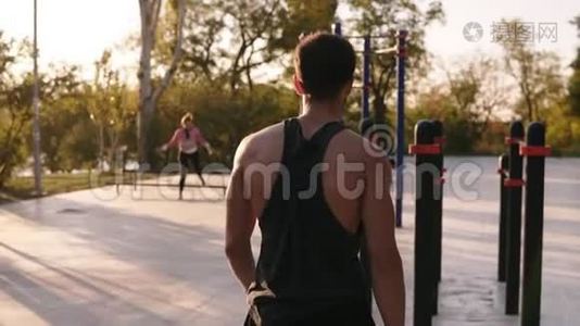 穿着衬衫的肌肉男来到当地运动场，开始在水平横杆上训练。 三头肌视频