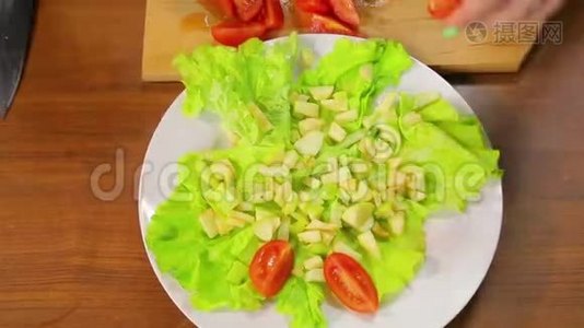 女性手把樱桃番茄片放在一盘沙拉里。 时间跨度视频