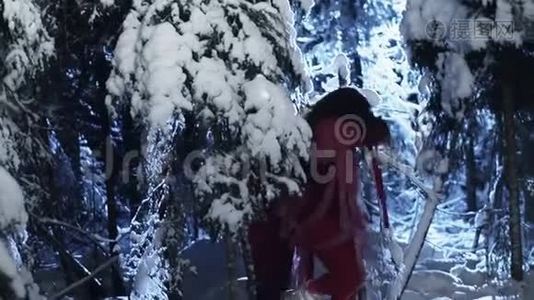 穿着红色服装的青年男女正在白雪皑皑的冬林中行走。视频