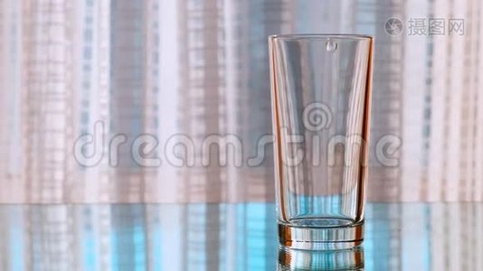 干净的饮用水被倒进玻璃杯里。 慢动作。视频