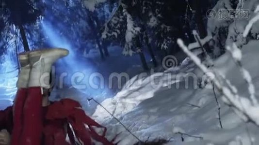 穿着红色衣服的可爱的男人和女人坐在冬天的森林里的雪地上。视频
