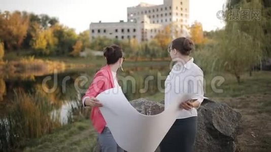 两名女建筑师和工程师在施工现场根据图纸和视频