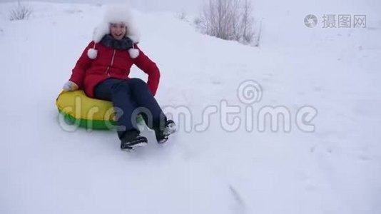 快乐的孩子滑在雪上滑在雪橇上，油管上。 女孩在公园里冬天玩。 白色的快乐少女视频