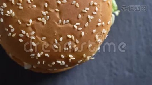 双奶酪汉堡和芝麻的特写从上往下看，面包旋转运动视频