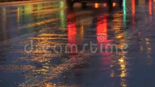 汽车在交通，前灯在雨中的沥青，视图下面。 晚上雨打水坑。 汽车`灯光的反射视频