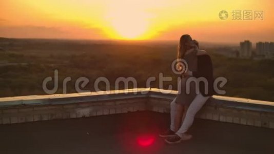屋顶上的浪漫约会。 可爱的情侣在日落时在屋顶上约会。视频
