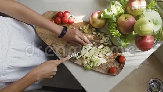 上景。 年轻的女人为冰沙准备苹果。 健康有意识的女孩切苹果吃素食。 一个女孩视频