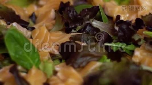 慢动作的美味三文鱼沙咪咪与绿色蔬菜叶。视频