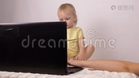 妈妈在她的小女儿的笔记本电脑上放了卡通片，小女孩看笔记本电脑，科技视频