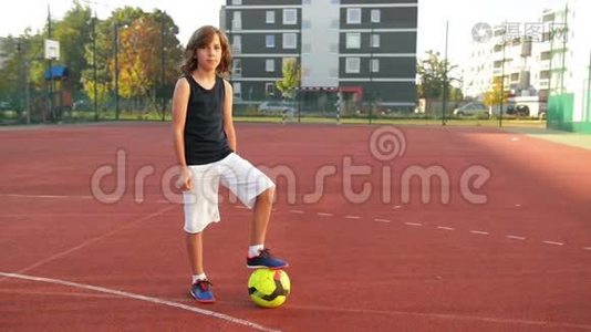 一个带足球的男孩的肖像。 体育理念。 他玩足球很有趣.视频