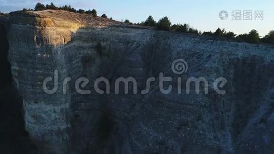 灰山崖的特写`顶上长满了针叶树，映衬着蓝天。 录像。 高山之夏视频