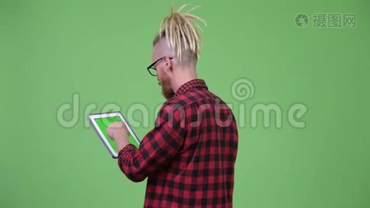 用数字平板电脑观看留着胡子的戴着可怕锁的时髦男士的背影视频