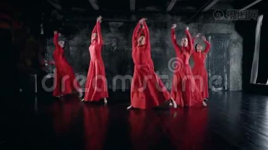 十几岁的女孩在排练室里表演舞蹈，穿着红色的裙子，跳跃和旋转视频
