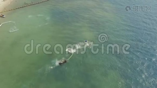 年轻人骑在飞板上，在蓝色的海水上喷水。 公海飞板骑手.. 水上运动视频