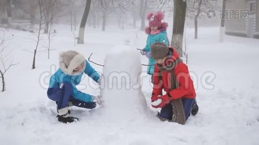 户外冬季家庭游戏。 妈妈和两个女儿一起塑造了雪人。视频