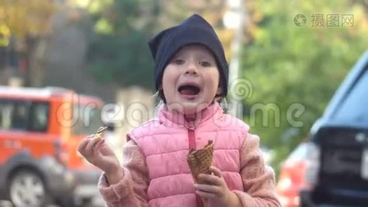 快乐女孩吃巧克力冰淇淋与华夫饼锥，美味的甜点。视频