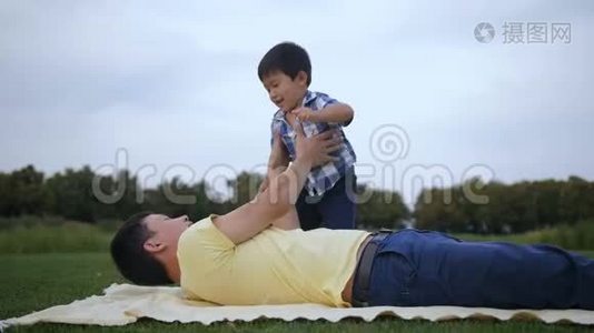 可爱的亚洲父亲举起他的笑男孩视频