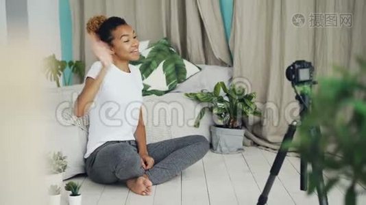 漂亮的非洲裔美国青少年vlogger正在为社交媒体的追随者录制视频，女孩正在看摄像机视频