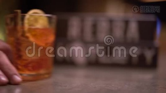男人的手用一块橘子和肉桂在桌子上的酒精射击视频