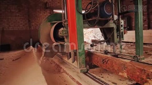 板上锯原木的机器沿着原木移动。 在锯木厂工作。视频