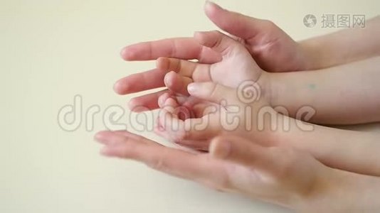 母亲的手抚摸着孩子的手特写，母亲的手慢慢地抚摸着孩子的手视频