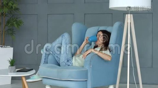 积极的女人在扶手椅上享受早咖啡视频