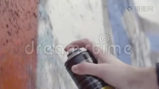 手拿一个喷漆罐和在墙上画彩色涂鸦，街头艺术理念.. 行动。 侧视图视频