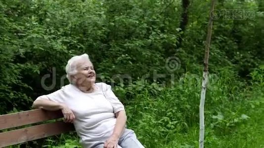 老奶奶坐在公园的长凳上休息视频
