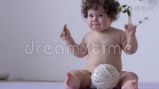 胖乎乎的裸体滑稽孩子手里拿着饼干在摄影棚的特写视频