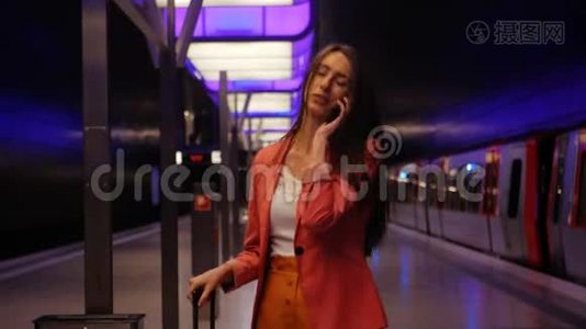 等待地铁-一位年轻的商务女性在智能手机上谈笑风生视频