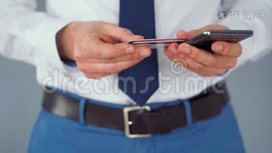 正式穿着的男人从几张信用卡中选择一张信用卡，并将其号码输入智能手机以在线支付。 网上在线视频