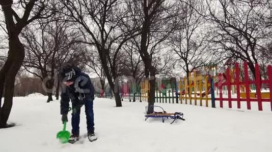 高清开朗的男孩正在雪地里和孩子们玩`铲子视频