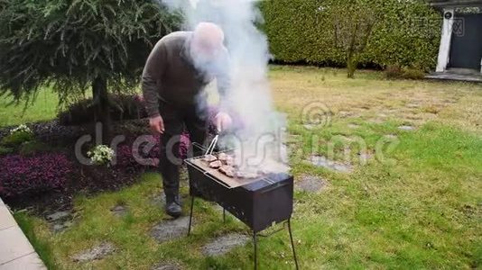 老人把肉烤在炭烤架上.视频