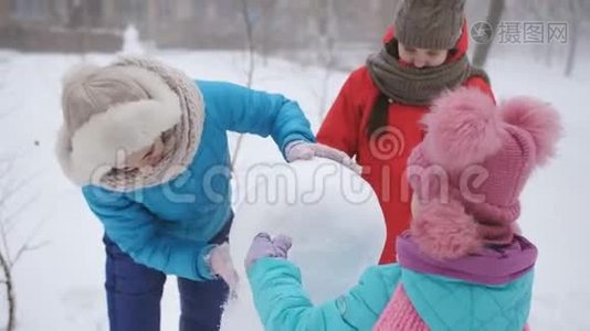 妈妈和两个女儿一起塑造了雪人。 户外冬季家庭游戏。视频