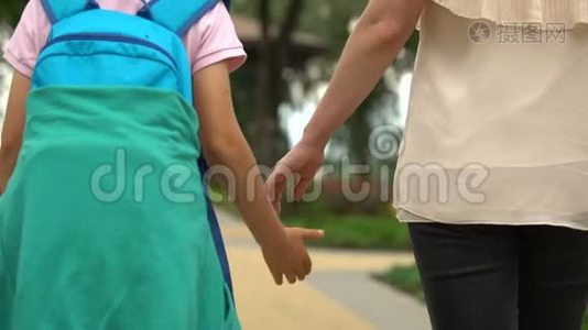 妈妈和孩子下课后步行回家，儿子在学校谈论白天视频