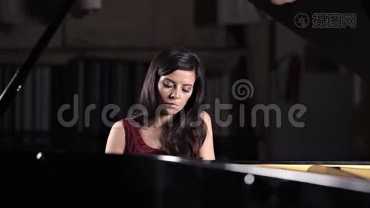 一个年轻女孩弹钢琴，音乐会前排练。 古典音乐视频