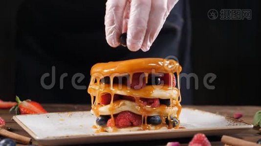 在家中或在家中享用美味的有机薄煎饼时，厨师用手将有机黑莓汁倒入其中视频